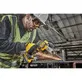 Pildil kasutab töömees DeWalt akulintlihvija DCM200E2T-d metalli lihvimiseks, tekitades sädemeid.