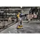 Pildil on DeWalt akulintlihvija DCM200NT, mis seisab metallpinnal tööstuslikus keskkonnas.