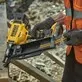 Pildil on näha DeWalt akunaelapüstol DCN910N, millega töömees kinnitab puidust konstruktsiooni.