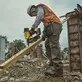 Pildil on töömees, kes kasutab ehitusplatsil DeWalt akunaelapüstolit DCN910N, et kinnitada puitlaudu.
