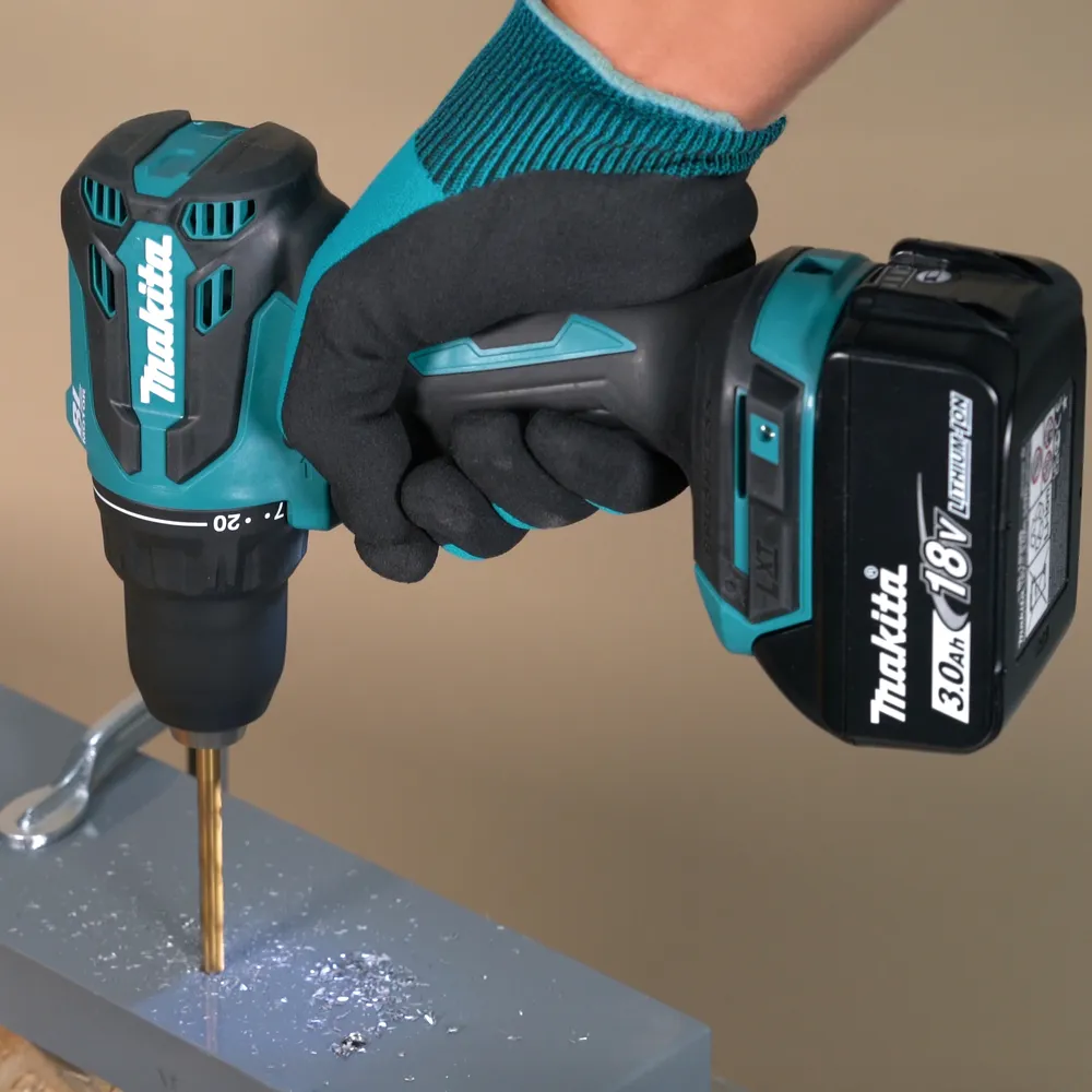 Pildil on Makita akutrell DDF490WF, mida hoitakse käes ja millega puuritakse auku halli pinda.