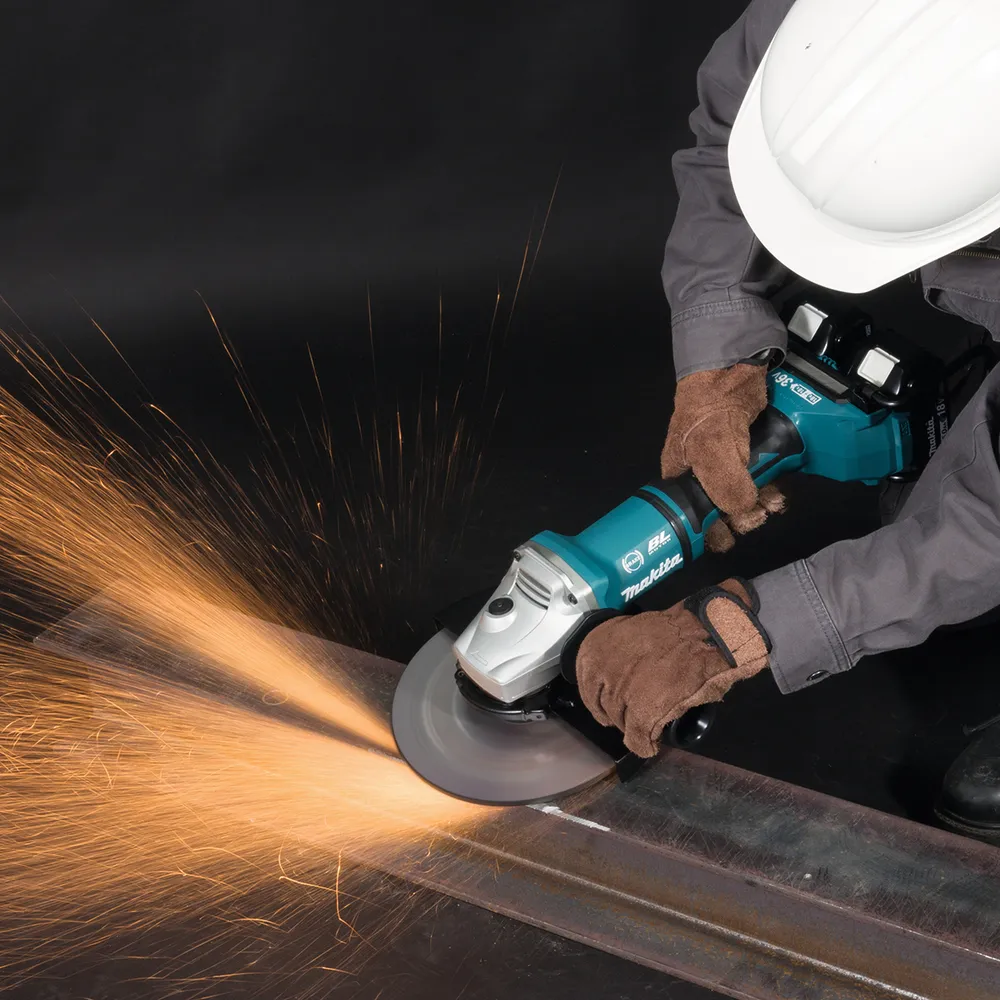 Makita akunurklihvija DGA900ZX1 on kujutatud töös oleval metallil, millelt paiskuvad sädemed.