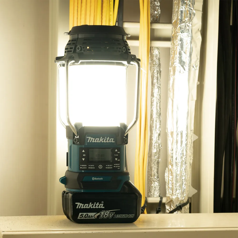 Pildil on Makita akulamp-raadio DMR056, mida valgustab sisseehitatud lamp, jättes samal ajal seljataha kollased ja...