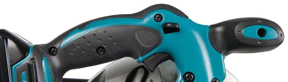 Pildil on detailne vaade Makita akuketassaagi DSS610Z käepidemele, kus on näha sae päästik, ohutusnupp ja ergonoomiline...