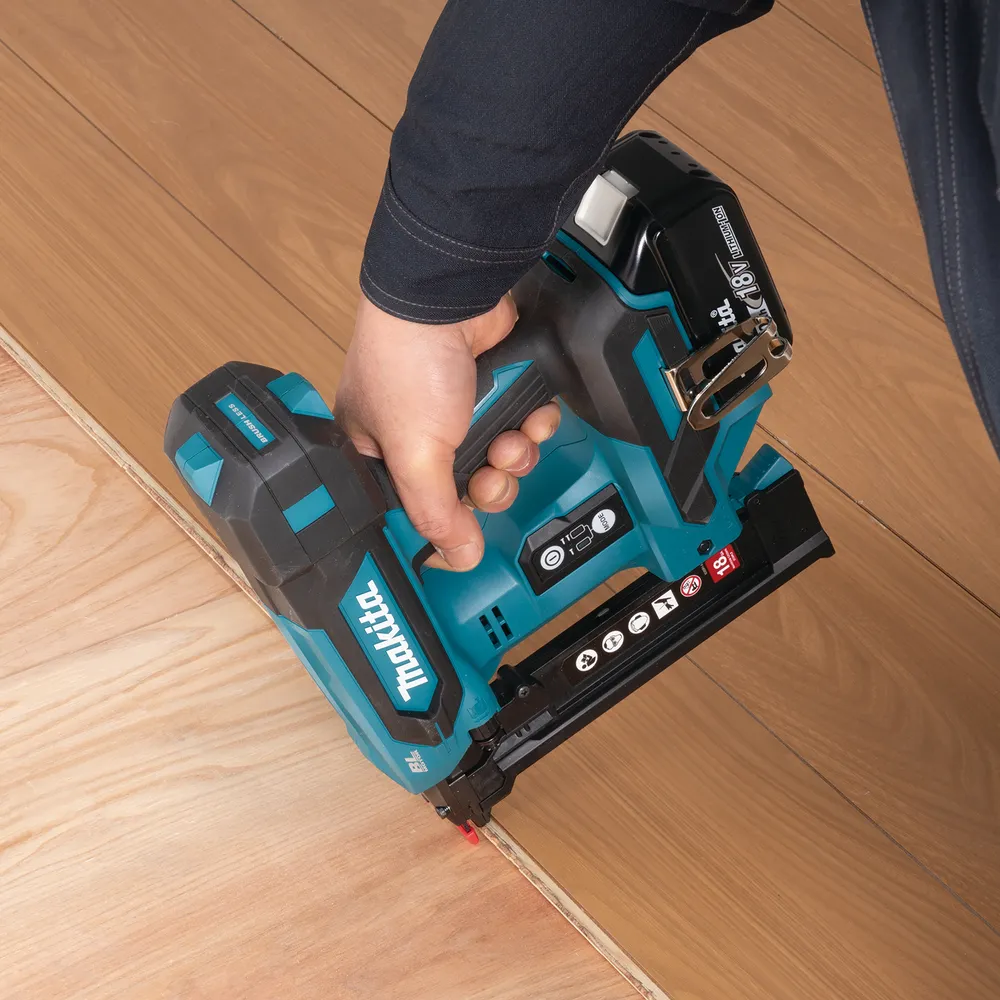Pildil on näha Makita akuklambripüstol DST630ZJ, mida inimene kasutab puidu kinnitamiseks.