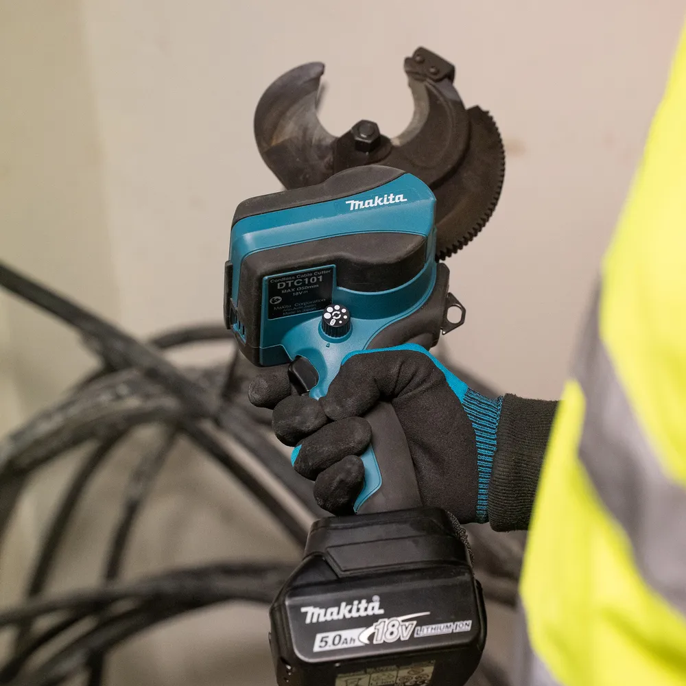 Pildil on Makita akukaablilõikur DTC101ZK, mida inimene hoiab käes, et lõigata pakse kaableid.