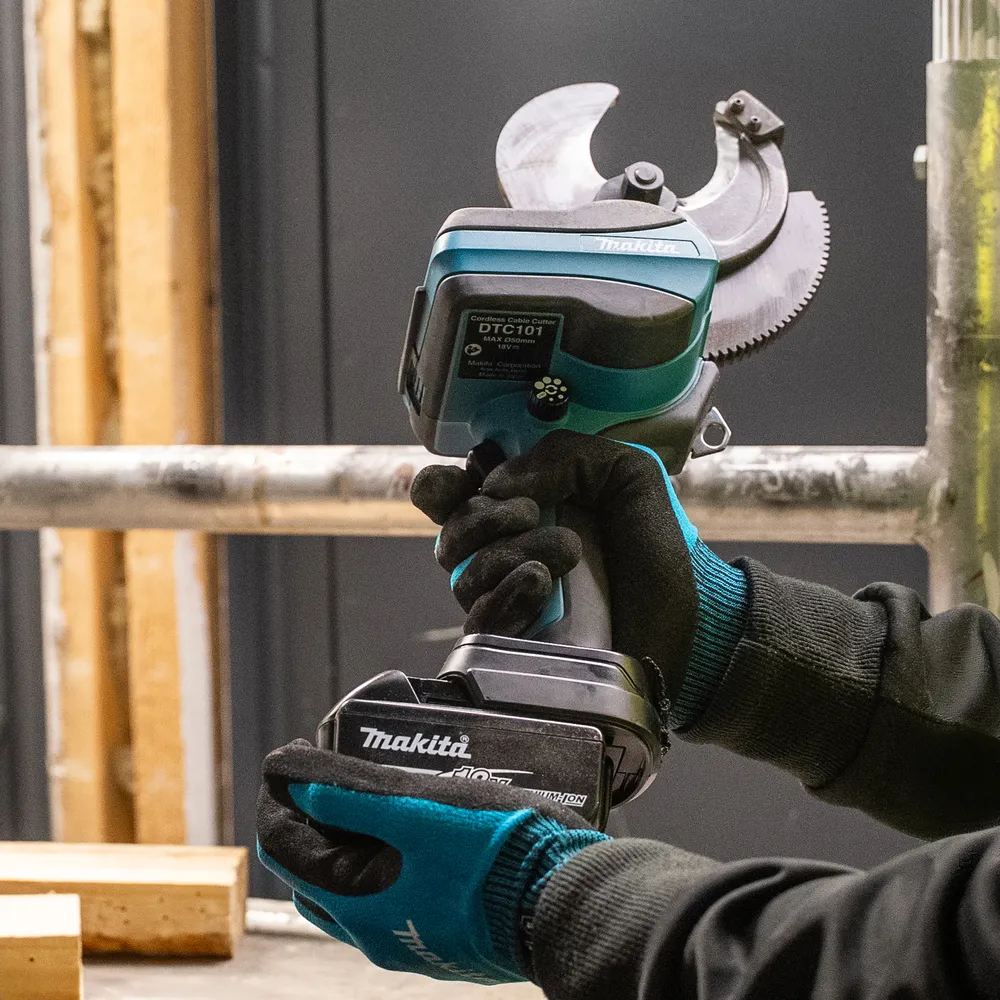 Pildil on Makita akukaablilõikur DTC101ZK, mida hoitakse käes tööstuslikus keskkonnas.