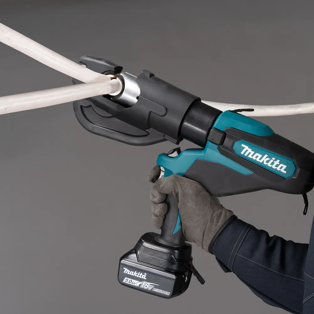 Pildil on käed, mis hoiavad Makita akukaablipressi DTC302ZK, mida kasutatakse kaablite pressimiseks elektrijaotussüsteemis.