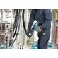 Pildil on elektrik, kes kasutab Makita akukaablipressi DTC303ZK, et suruda kaableid suuremas elektrisüsteemis.