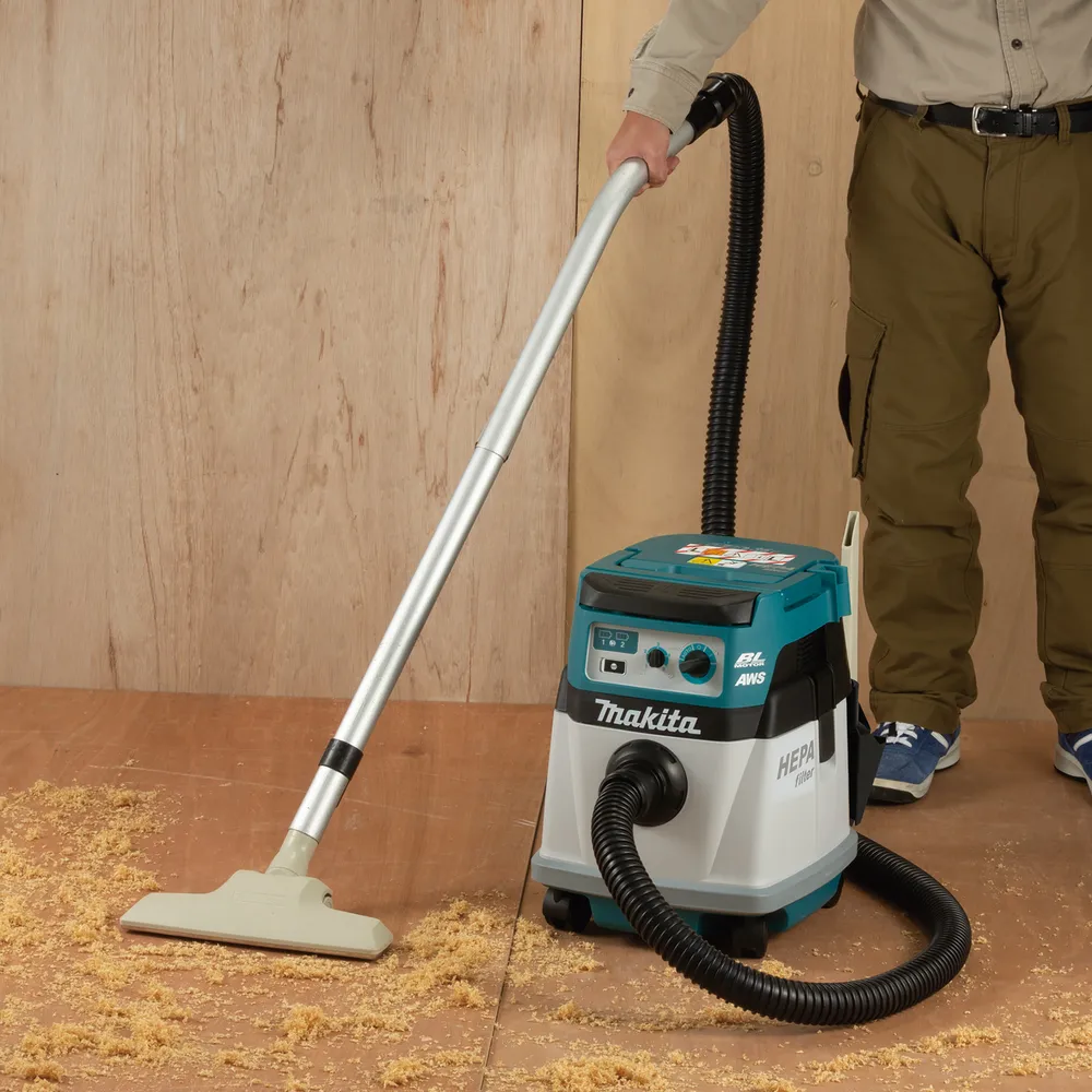 Pildil on Makita akutolmuimeja DVC157LZX3, mida kasutatakse puiduhakke koristamiseks.