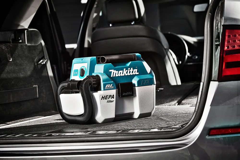 Pildil on Makita akuga vee- ja tolmuimeja DVC750LZ, mis on asetatud auto pakiruumi.