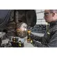 Pildil on näha töömees, kes kasutab Dewalt akuotslihvijat DCG421N, et lihvida auto piduriketast.