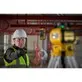 Pildil näeb mees kandmas turvariideid, kasutades DeWalt pöördlaserit DCLE15221G tööriista torustiku paigaldamisel.