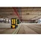 Pildil on näha DeWalt pöördlaser DCLE15221G, mis projekteerib rohelisi lasereid ehitusobjektil põrandale ja seinale.