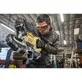 Pildil on mees, kes kasutab Dewalt akutoitel lintsaagi, et lõigata metallist toru.