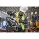 Pildil on Dewalt akutoitel lintsaag, mida mees kasutab töökojas metalltoru lõikamiseks.