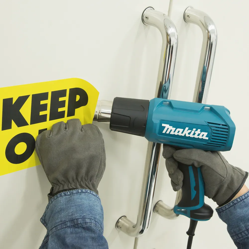 Pildil on Makita kuumaõhufööniga eemaldatav "KEEP OUT" silt ustelt.