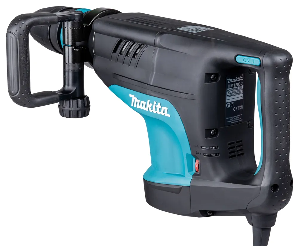Pildil on Makita piikvasar HM1203C, millel on küljel reguleeritav käepide, suur käepide ja turvalüliti.