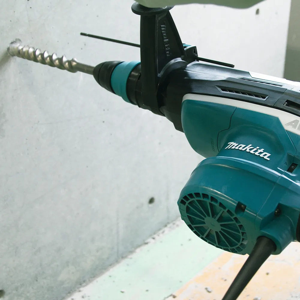 Pildil on näha Makita kombivasar HR5212C SDS-MAX, mis puurib betoonseina.
