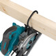 Makita akuketassaag HS014GZ, ilma aku ja laadijata, on pildil kujutatud puurimise ajal puidust detaili külge kinnitatuna.