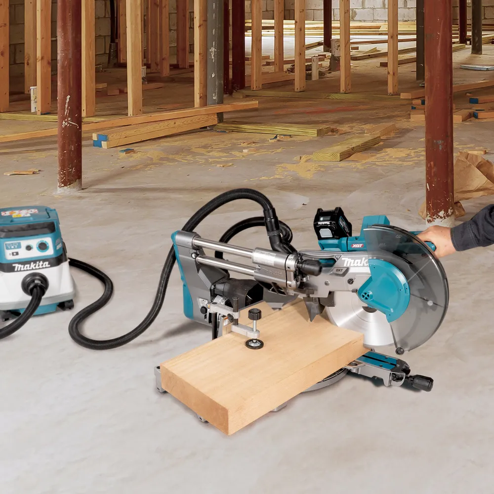 Pildil on Makita akuga tükeldus- ja nurksaag LS003GZ01 koos Makita tolmuimejaga töökeskkonnas, kus on näha...