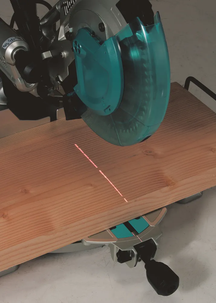 Pildil on näha Makita tükeldus- ja nurksaag LS1019L koos punase lasermärgistusega puidust toorikul.