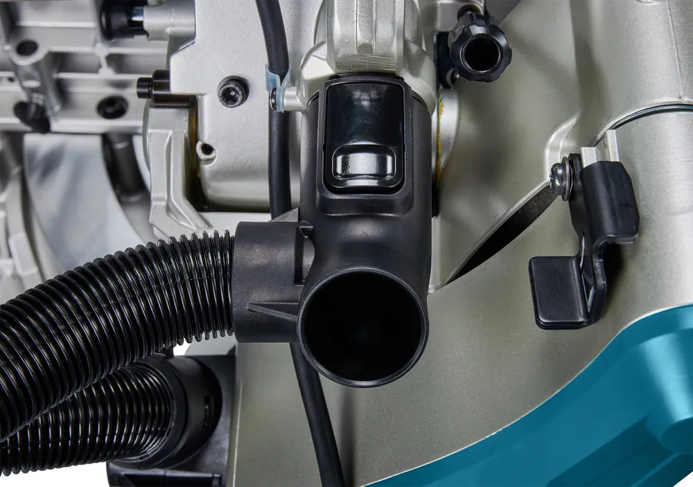 Pildil on näha Makita tükeldus- ja nurksaag LS1219L detail, mis keskendub mustale tolmuimeja voolikule ja selle...