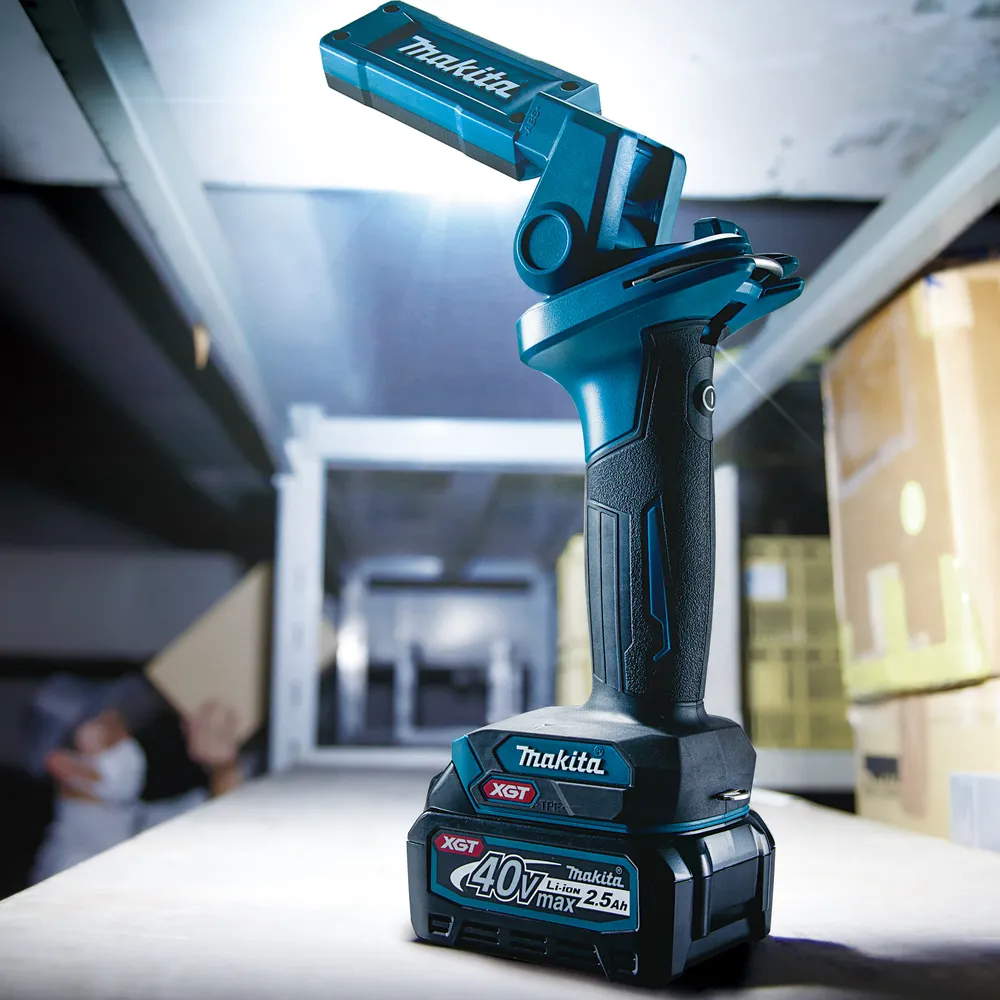 Pildil on Makita akulamp ML006GX, mis valgustab lao riiuleid.