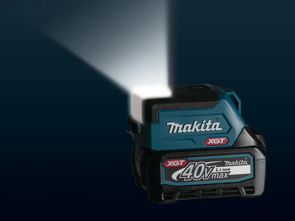 Pildil on Makita akulamp ML011G, mis heidab eredat valgust tumedale taustale.