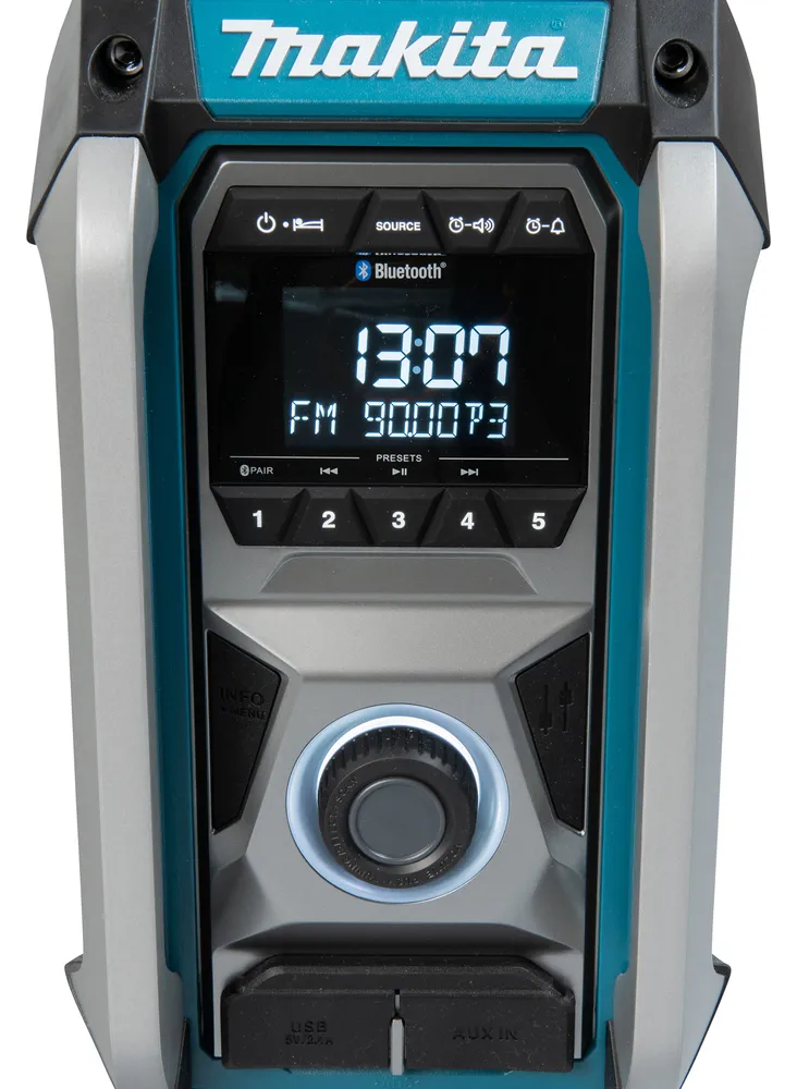 Pildil on näha Makita MR006GZ tööraadio, millel on digitaalne ekraan, juhtnupud ja pordid.