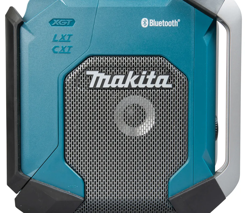 Pildil on kujutatud Makita MR006GZ Bluetooth-raadio, mille keskel on metallvõrega esipaneel ja suurelt kirjutatud...