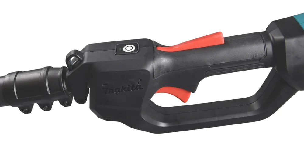 Pildil on Makita akutoitel teleskoop-oksasae UA004GM101, XGT käepide, kus on näha toitenupp, päästik ja Makita logo.