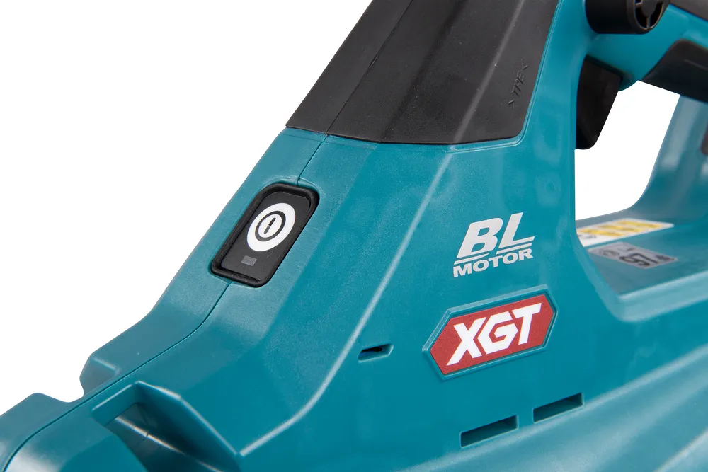 Pildil on näha osa Makita akupuhuri UB001GZ XGT sinisest korpusest koos sisselülitusnupuga ja "BL MOTOR" ning "XGT" logodega.