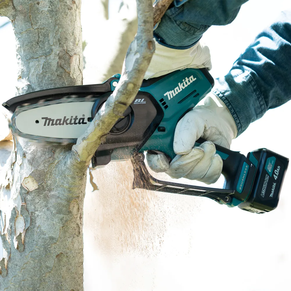 Pildil on näha Makita akuoksasaag UC100DWA, millega saetakse puud.