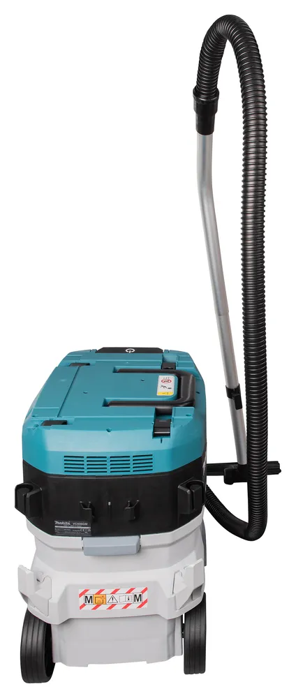 Pildil on Makita akuga vee- ja tolmuimeja VC006GMZ01, millel on sinine pealmine osa ja valge alumine osa koos ratastega...