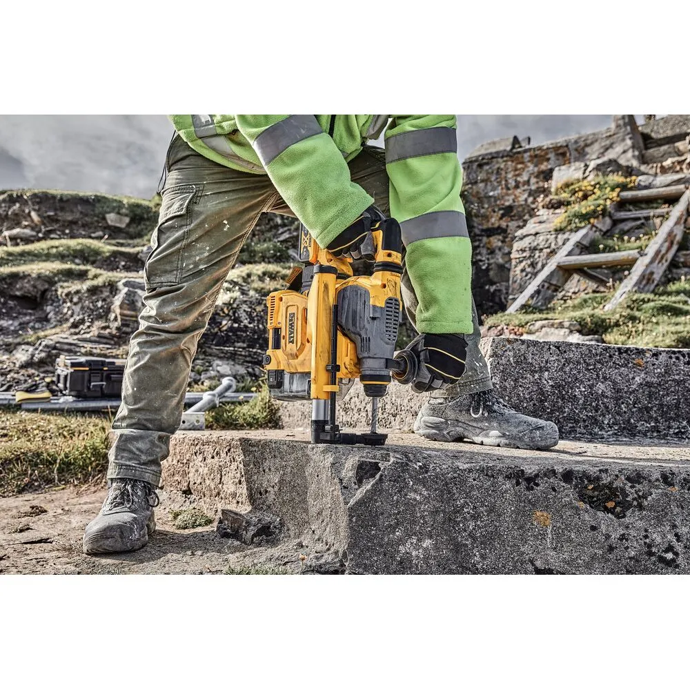 Pildil on näha tööriistaga töötav inimene, kes kasutab Dewalt tolmueemaldussüsteemi SDS Plus D25304DH.