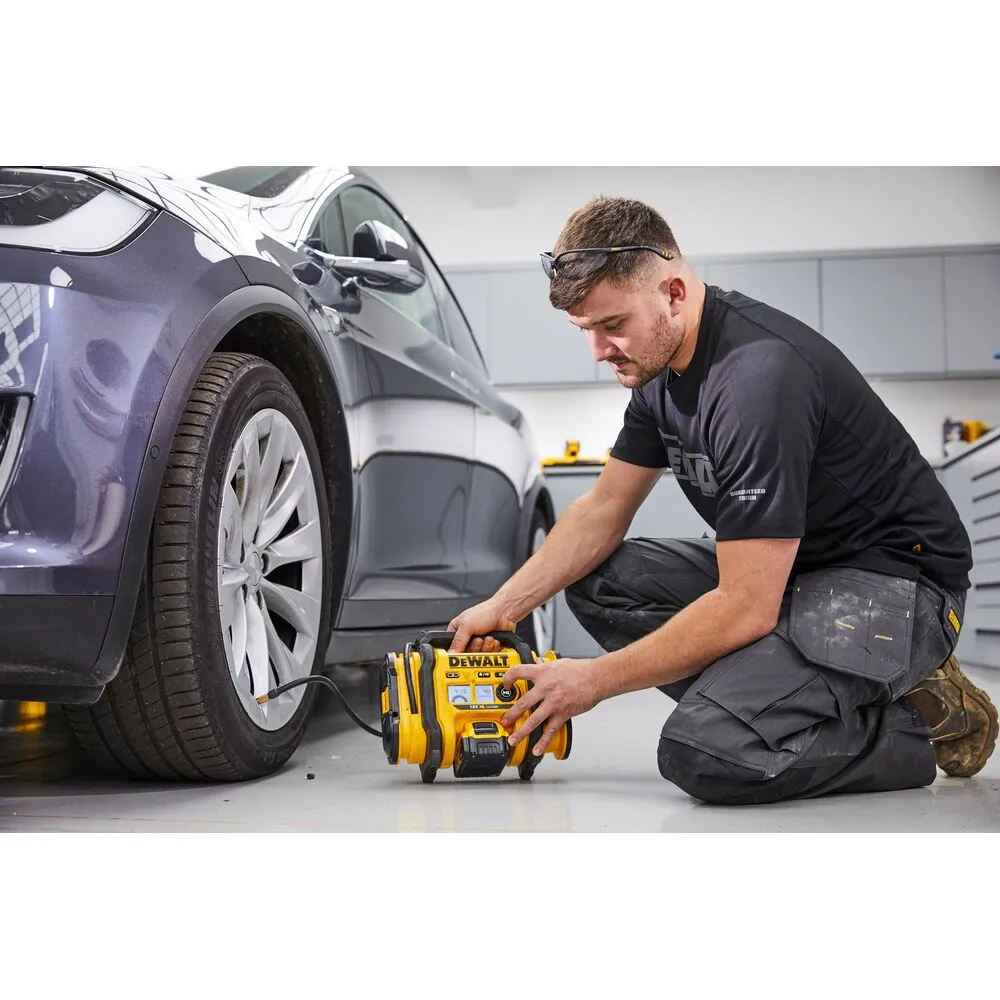 Pildil näeb mees kasutamas Dewalt akutoitel kompressorit, et täita auto rehvi.