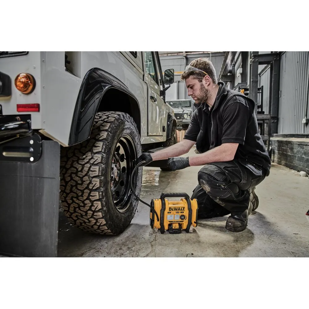 Pildil on DeWalt akutoitel kompressor DCC018N, mida mees kasutab auto rehvi täispumpamiseks.