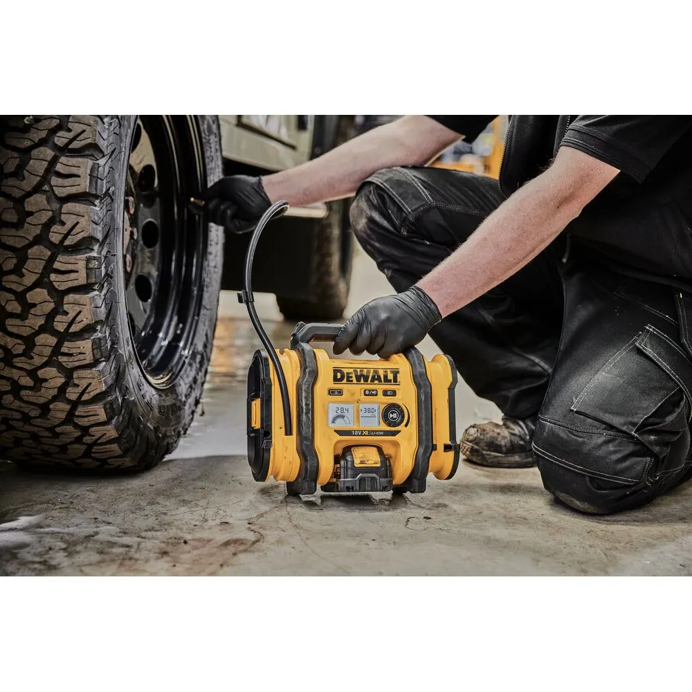 Pildil on DeWalt akutoitel kompressor DCC018N, mida inimene kasutab rehvi täispumpamiseks.