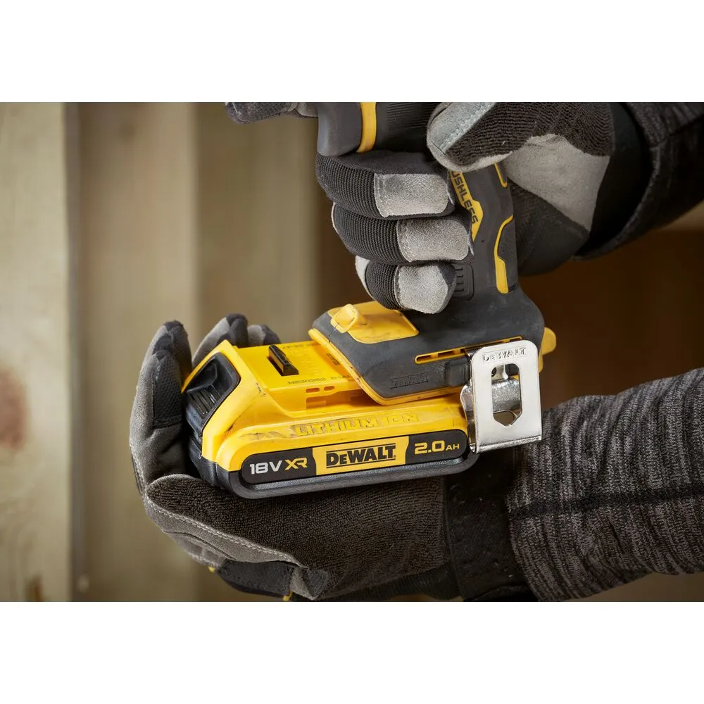 Pildil on näha käed töökindade sees, mis hoiavad DeWalt akutrelli koos kahe 2,0 Ah akuga.