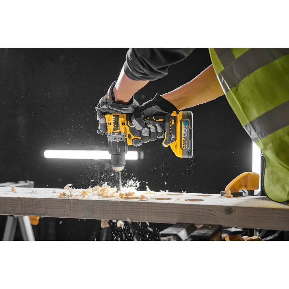 Pildil on näha, kuidas töömees kasutab DeWalt akulööktrelli puidu puurimiseks, mille käigus tekib hööveldustolm.