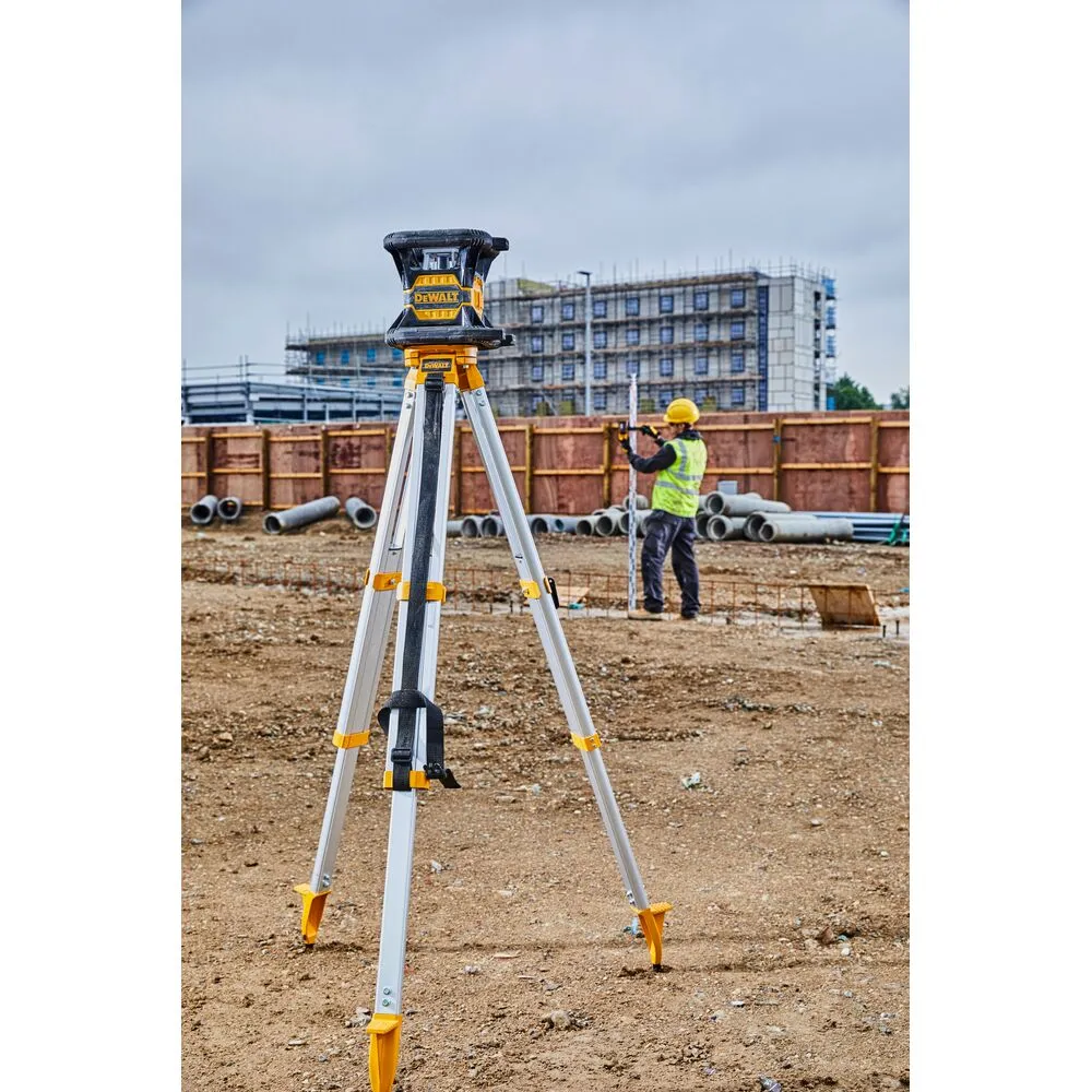 Pildil on näha DeWalt pöördlaser DCE080D1RS statiivil ehitusplatsil, kus taustal seisab töömees.