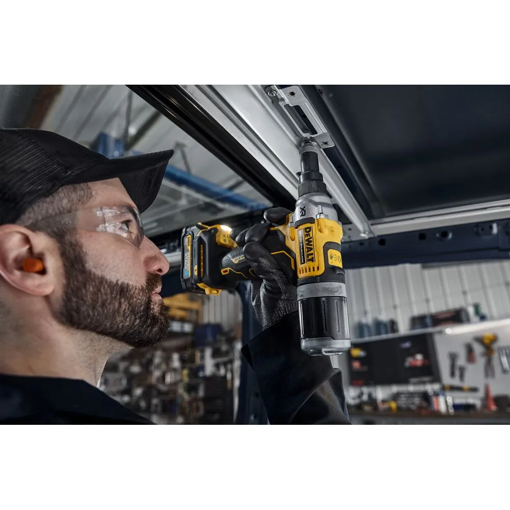 Pildil näeb, kuidas mees kasutab DeWalt akutoitel needipüstolit, mis kinnitab metallkonstruktsiooni.