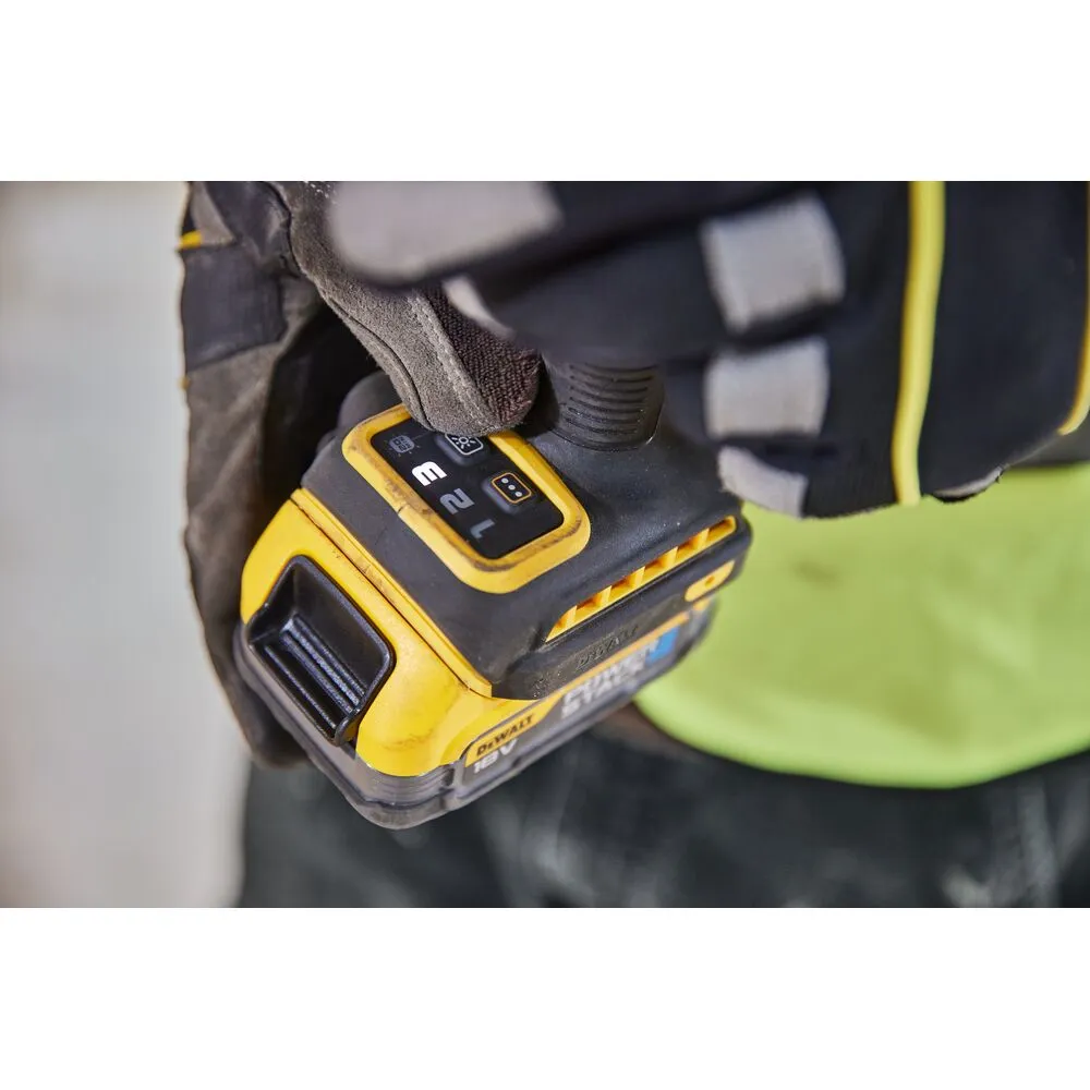 Pildil on näha Dewalt löökkruvikeeraja DCF860E2T, mida hoiab käes töökindaga inimene.
