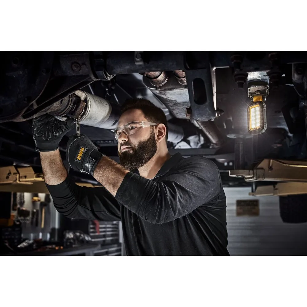 Pildil on mees, kes parandab autot, kasutades oma töös DeWalt laetavat USB-C LED töövalgustit.