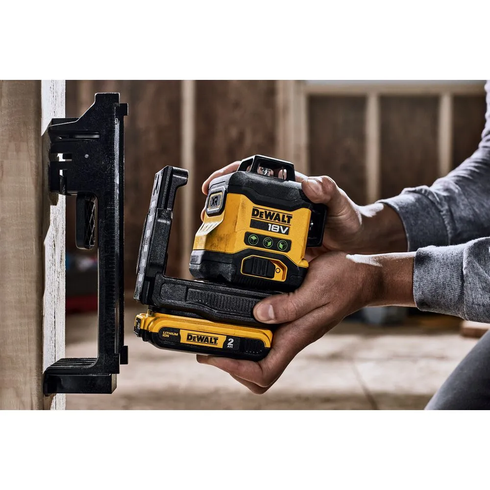Pildil on näha DeWalt ristlaser, mida hoitakse käes ning mis on kinnitatud tööriista magnetkinnituse külge.