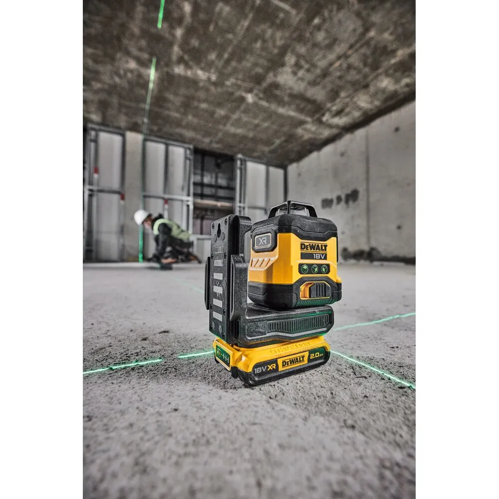 Pildil on näha DeWalt 18V XR ristlaser, mis projitseerib rohelisi lasereid betoonpõrandale ja lakke ehitusobjektil.