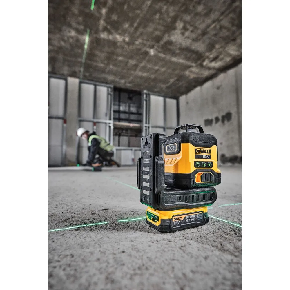 Pildil on näha kollane ja must Dewalt ristlaser, mis projitseerib rohelisi lasereid ehitusplatsil, kus inimene valge...