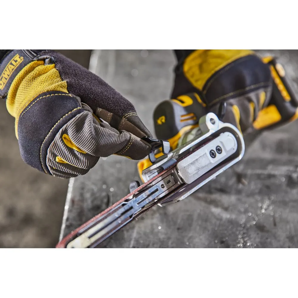 Pildil on näha DeWalt akulintlihvija DCM200NT, millega tööd tegev isik paigaldab rihma, kandes DeWalt töökindaid.