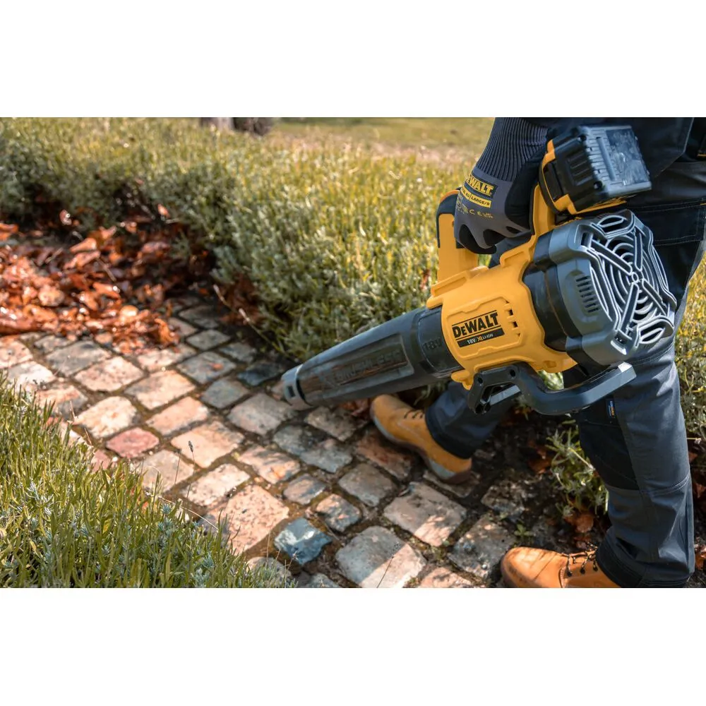 Pildil näeb kasutaja hooldamas oma aeda DeWalt akutoitega lehepuhuriga DCMBL562P1.